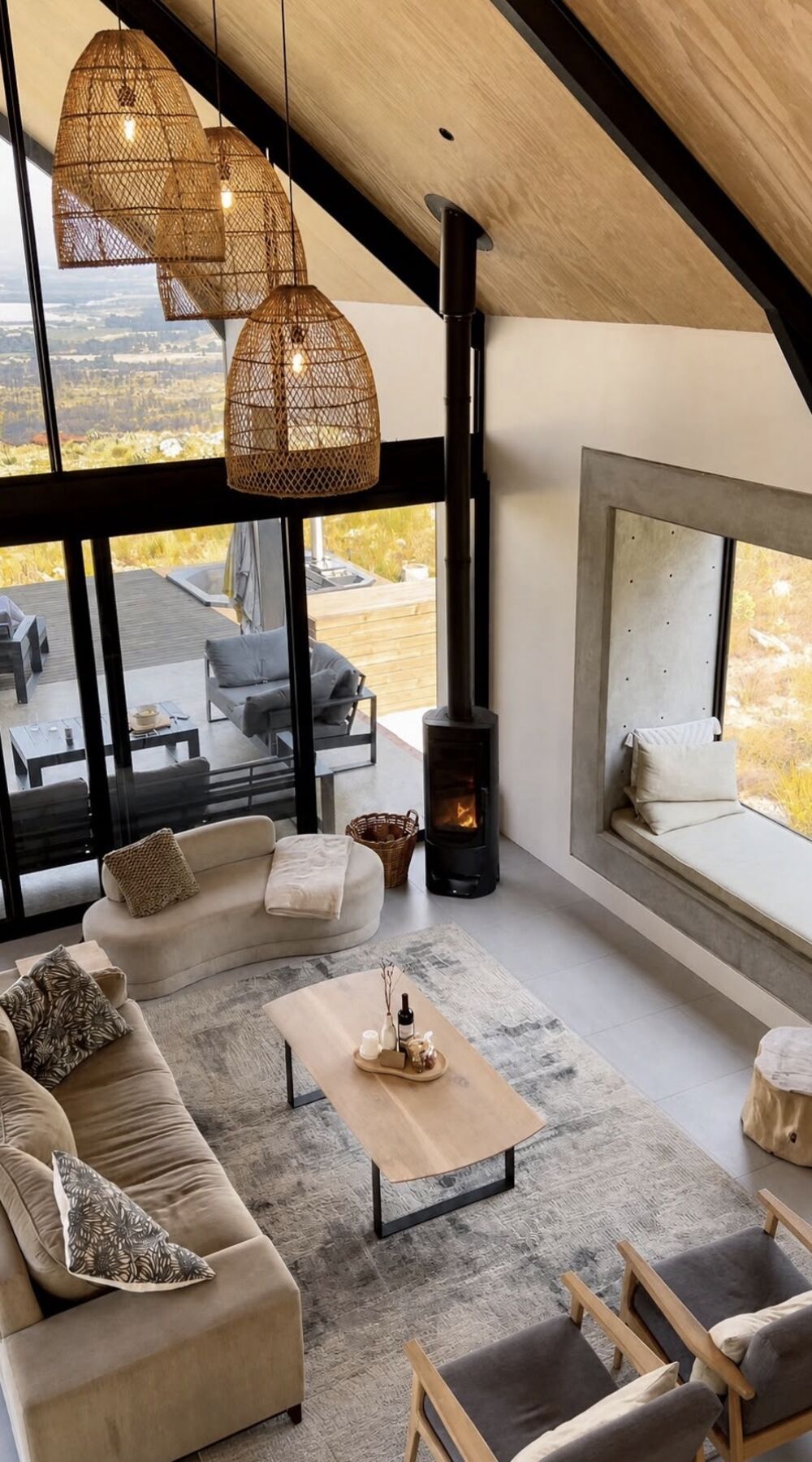Double-volume lounge with wicker pendants and a fireplace